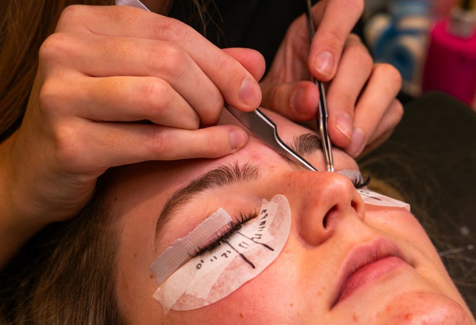A detailed view of a lash extension beauty procedure with close-up on tools and eye.
